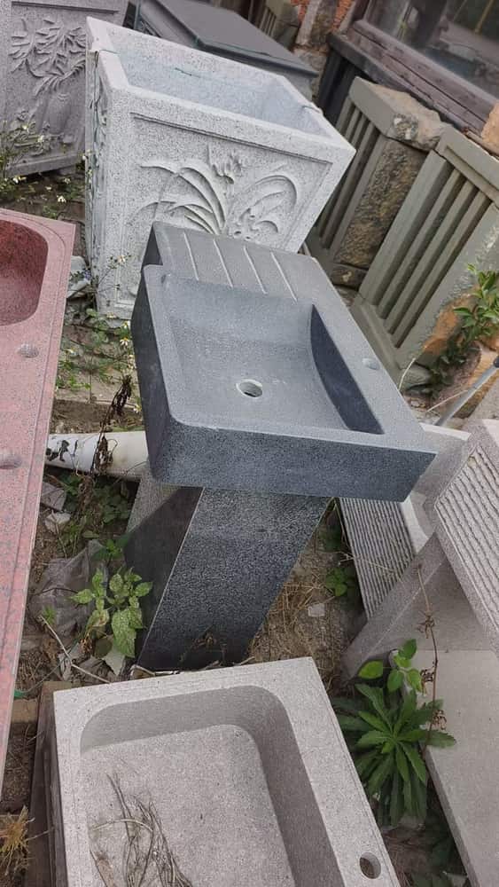 Long rectangular stone wash basin photographed from the side in the workshop