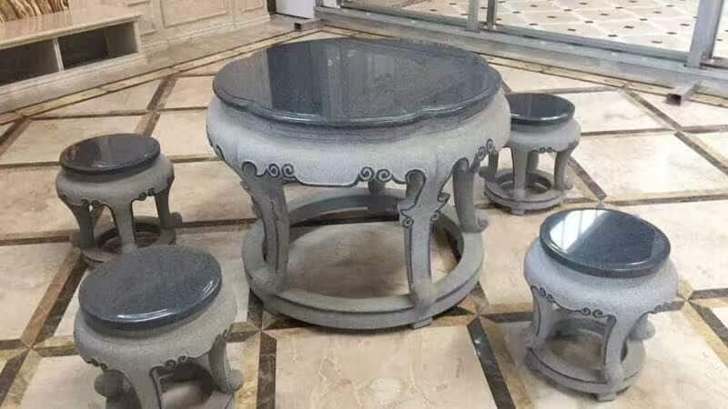 Round stone table and matching stools displayed in the workshop