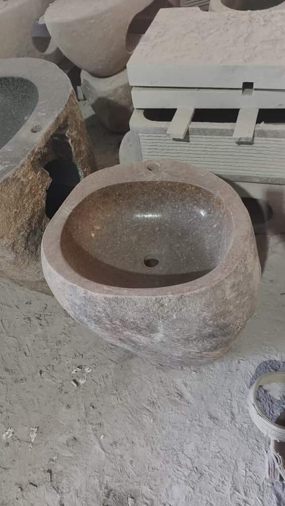Round natural stone wash basin photographed in the workshop