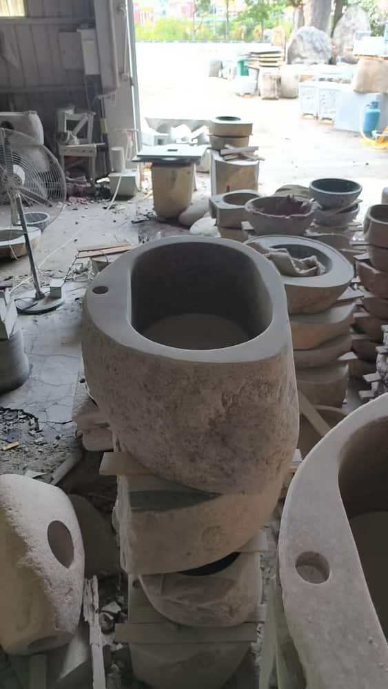 Tall pedestal natural stone wash basin photographed in the workshop