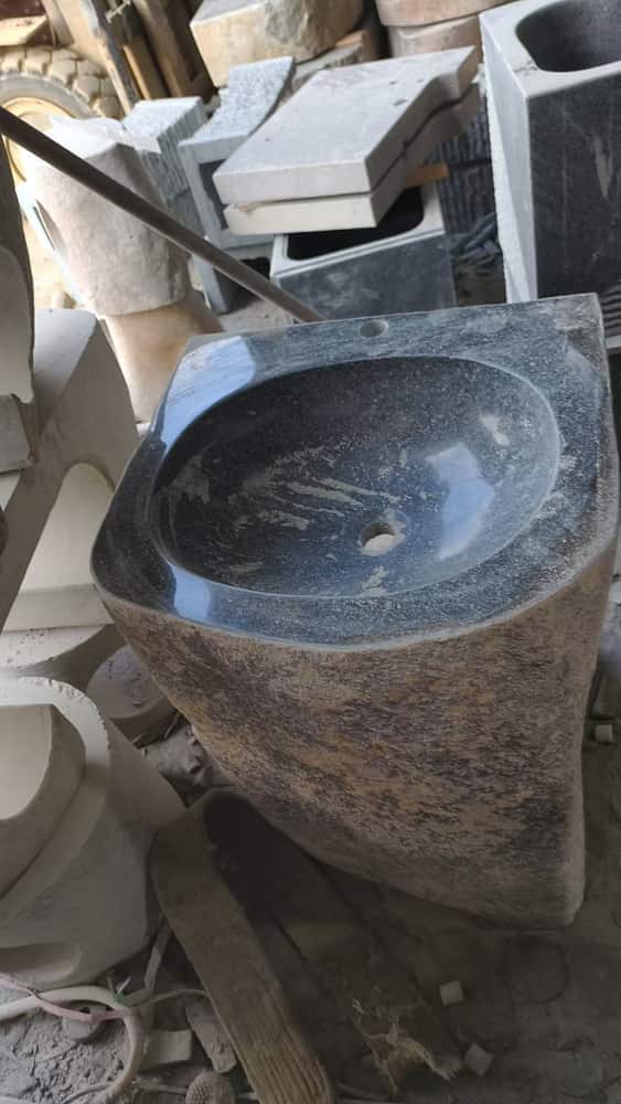 Tall rustic natural stone pedestal basin photographed in the workshop