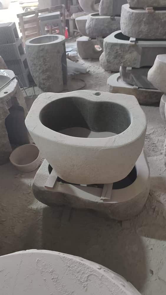 Round stone pedestal wash basin photographed in the workshop