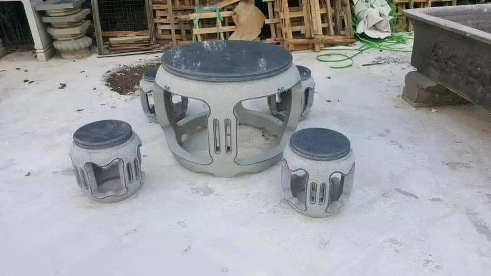 Round stone table with matching stools in the WANQI STONE workshop